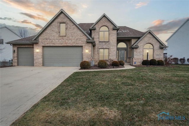 french provincial home featuring a lawn and a garage