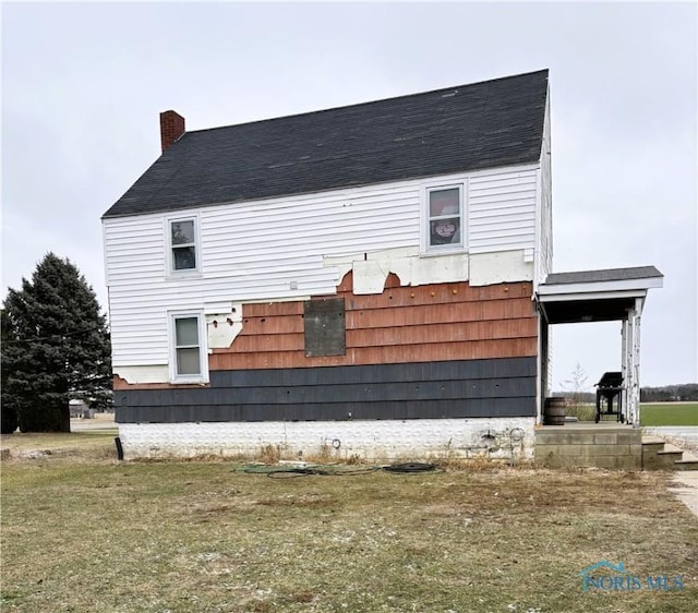 view of side of property with a lawn