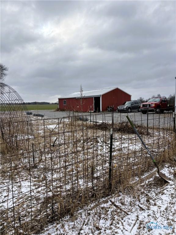 snowy yard featuring an outbuilding