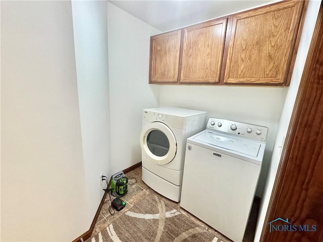 clothes washing area featuring cabinets, light tile patterned floors, and washer and dryer