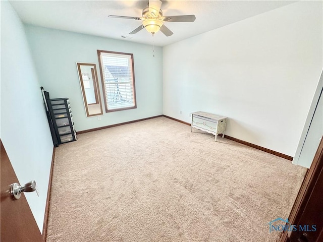 empty room featuring light colored carpet and ceiling fan