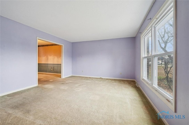 carpeted spare room featuring a wealth of natural light