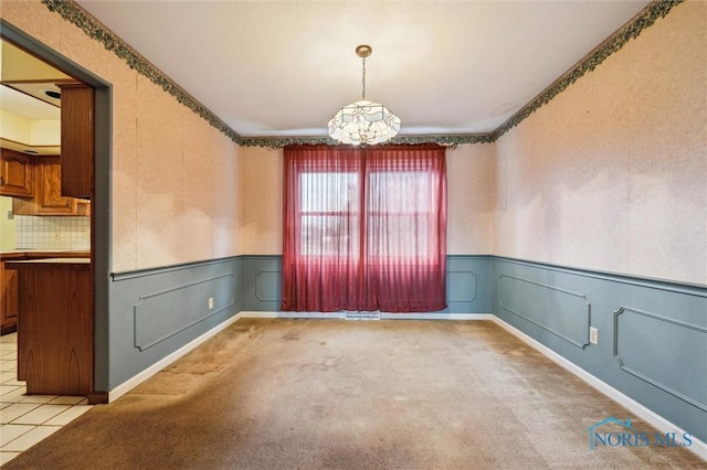 unfurnished room with light carpet and a notable chandelier