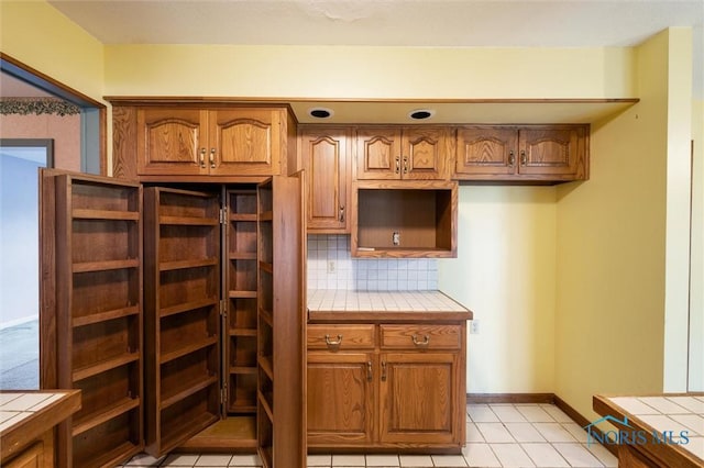 kitchen with tile countertops, light tile patterned floors, and tasteful backsplash