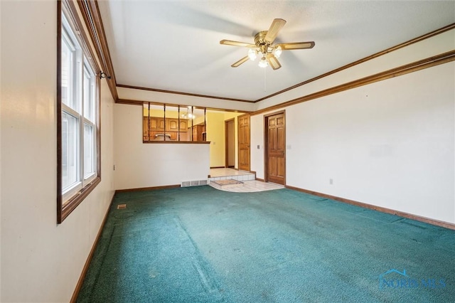 empty room featuring carpet, plenty of natural light, ceiling fan, and ornamental molding