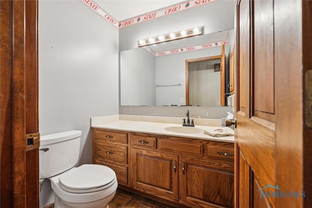 bathroom with vanity, toilet, and parquet floors