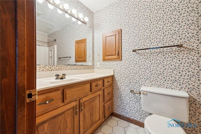 bathroom with tile patterned flooring, vanity, toilet, and walk in shower