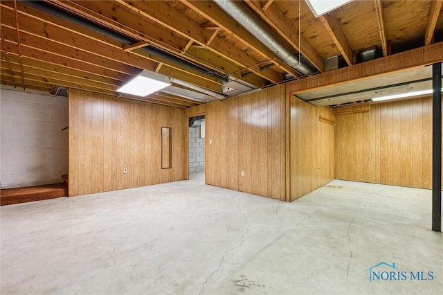 basement featuring wood walls