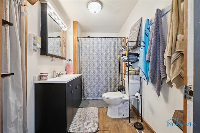 bathroom with toilet, hardwood / wood-style flooring, and vanity