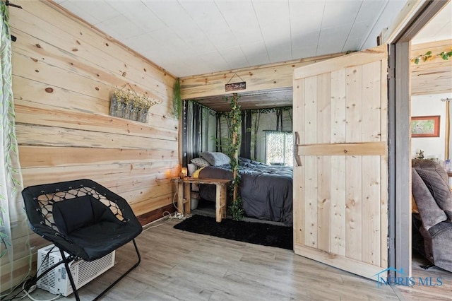 bedroom featuring hardwood / wood-style floors and wood walls