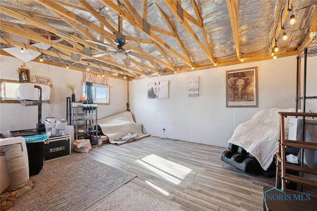 misc room with wood-type flooring, ceiling fan, and vaulted ceiling with beams