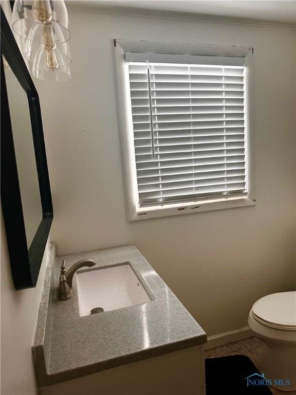 bathroom featuring vanity, a healthy amount of sunlight, and toilet