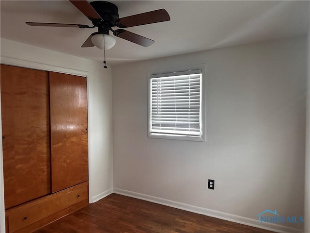 unfurnished bedroom featuring a closet, ceiling fan, and dark wood-type flooring