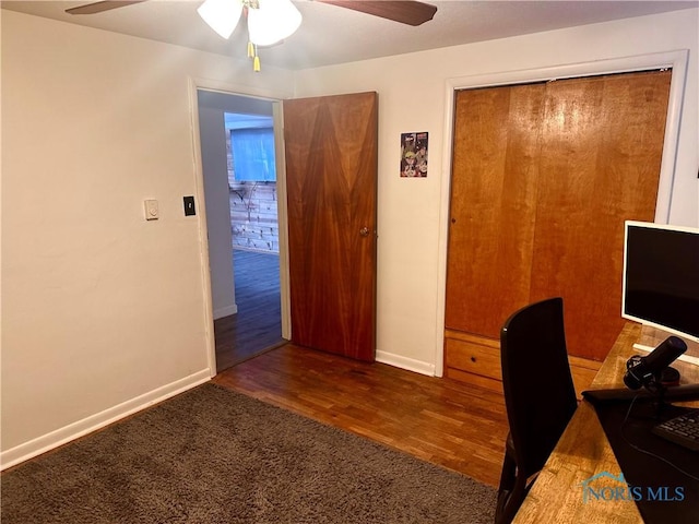 unfurnished office featuring ceiling fan and dark hardwood / wood-style floors