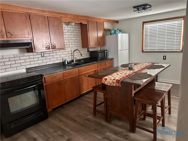 kitchen with black appliances, dark hardwood / wood-style flooring, sink, and tasteful backsplash