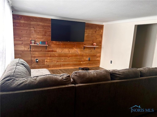 living room with wooden walls and a textured ceiling