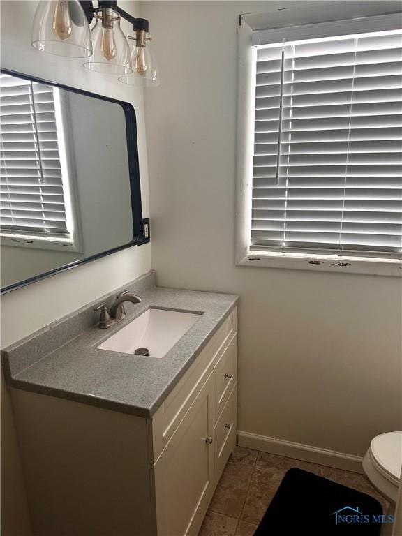 bathroom with tile patterned flooring, vanity, and toilet