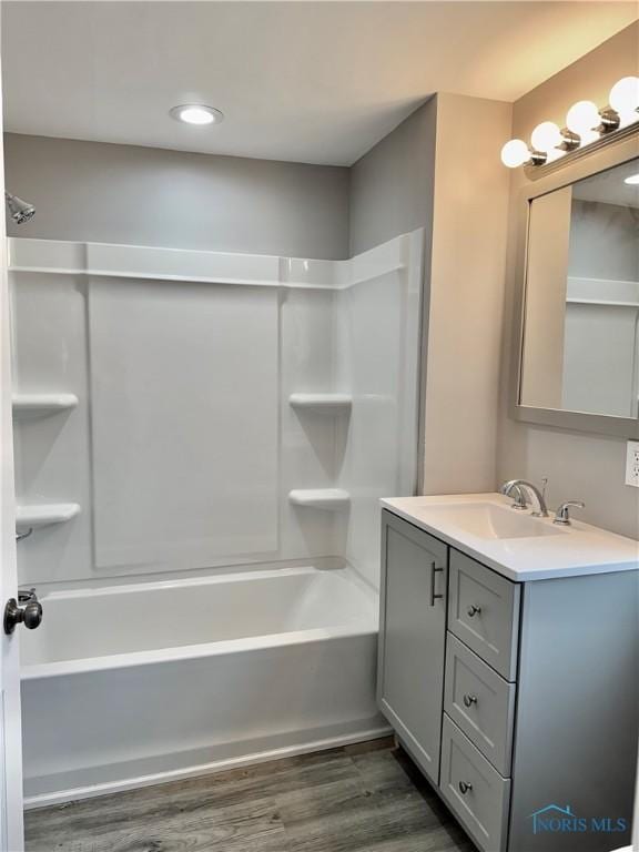 bathroom featuring vanity, hardwood / wood-style floors, and shower / washtub combination