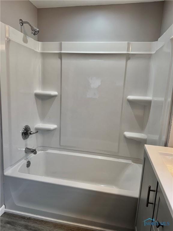 bathroom with hardwood / wood-style flooring, shower / bath combination, and vanity