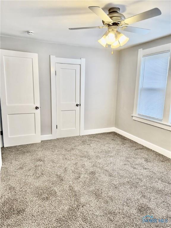 unfurnished room with ceiling fan and carpet floors