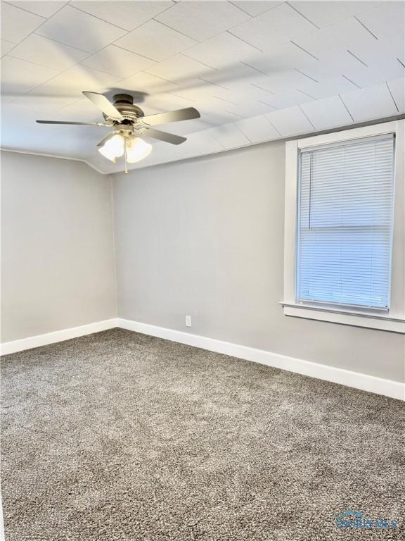 carpeted spare room featuring ceiling fan