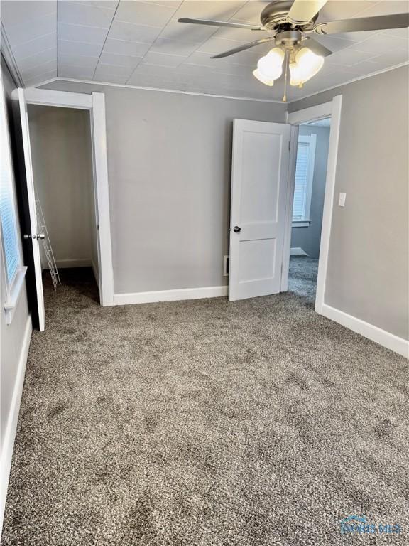 unfurnished bedroom featuring ceiling fan and carpet flooring