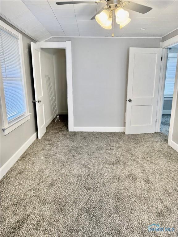 unfurnished bedroom with ceiling fan, carpet floors, and lofted ceiling