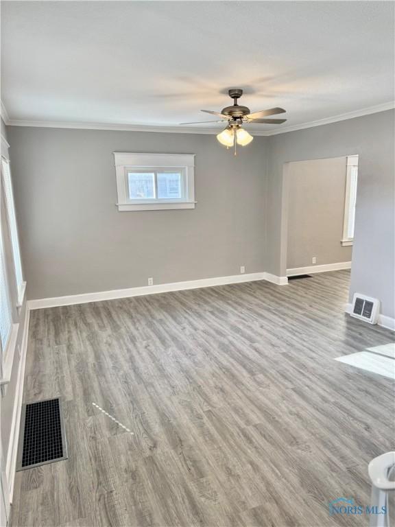 spare room featuring ceiling fan, hardwood / wood-style floors, and crown molding