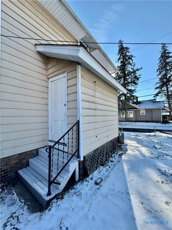 snow covered property featuring cooling unit