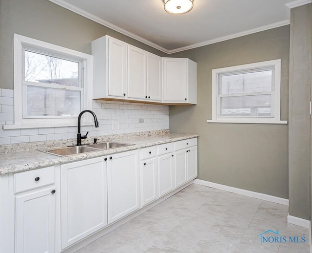 kitchen featuring tasteful backsplash, white cabinetry, ornamental molding, and sink