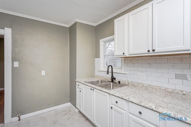 kitchen with decorative backsplash, white cabinetry, ornamental molding, and sink