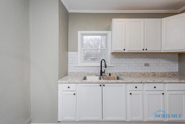 kitchen featuring white cabinets, ornamental molding, sink, and tasteful backsplash