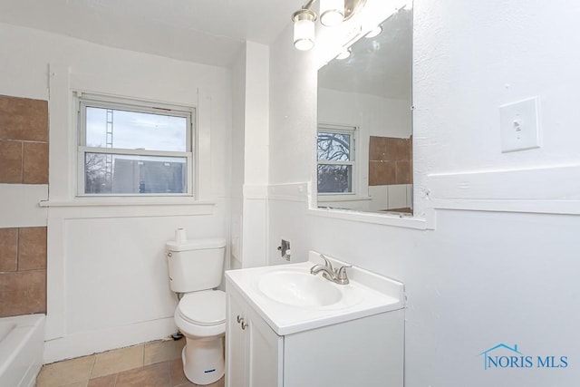 bathroom featuring tile patterned floors, vanity, toilet, and a bathtub