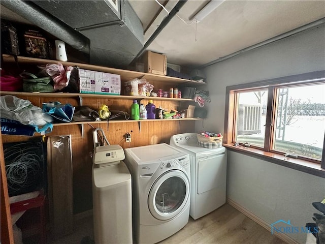 clothes washing area featuring light wood-type flooring and separate washer and dryer