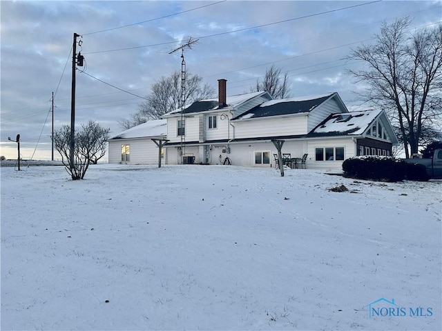 snow covered property with cooling unit