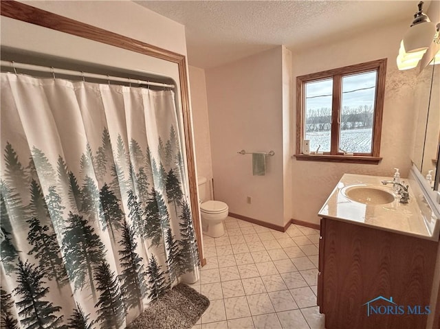 bathroom with vanity, toilet, and a textured ceiling