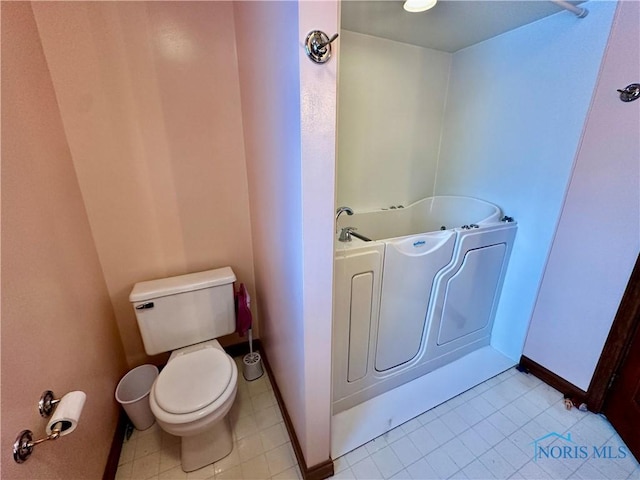 bathroom featuring a washtub and toilet