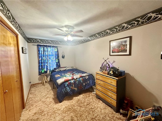 carpeted bedroom with ceiling fan and a closet