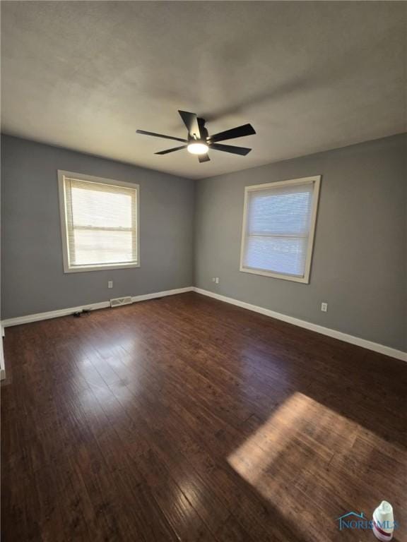 spare room with dark hardwood / wood-style floors and ceiling fan