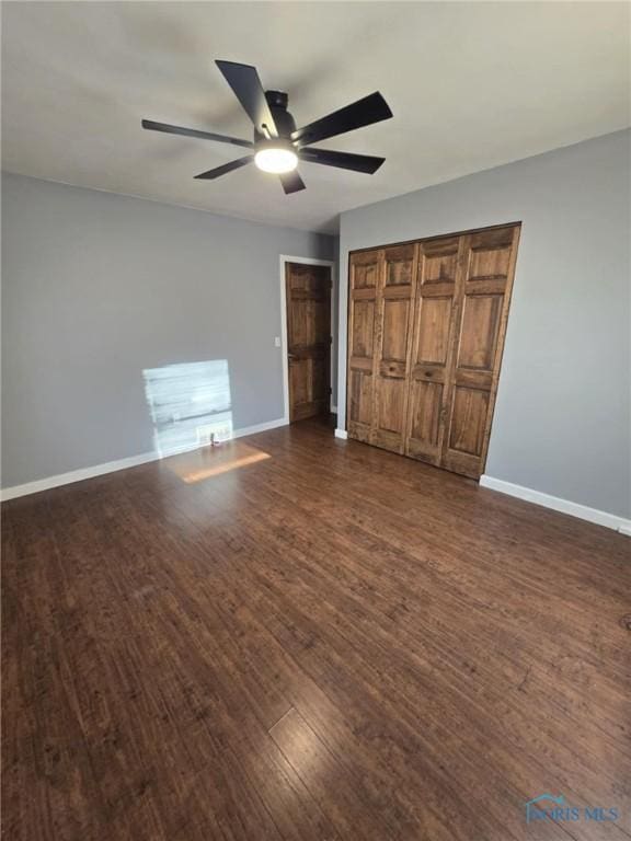 unfurnished bedroom featuring ceiling fan and dark hardwood / wood-style flooring