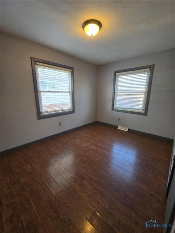 spare room with dark hardwood / wood-style floors