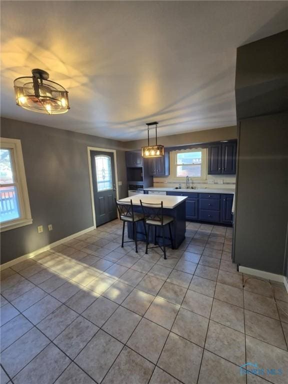 kitchen with hanging light fixtures, a healthy amount of sunlight, a center island, and a breakfast bar