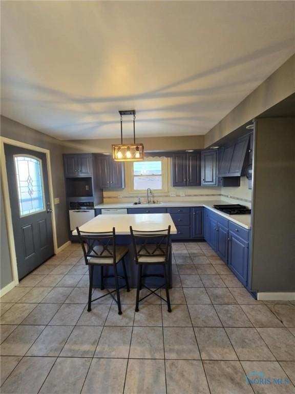 kitchen with decorative light fixtures, a wealth of natural light, a center island, and a kitchen bar