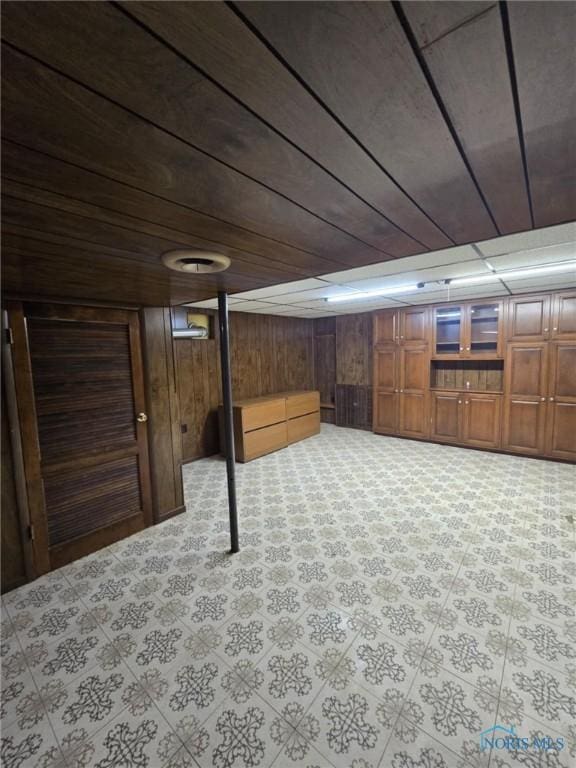 basement featuring wood ceiling and wooden walls