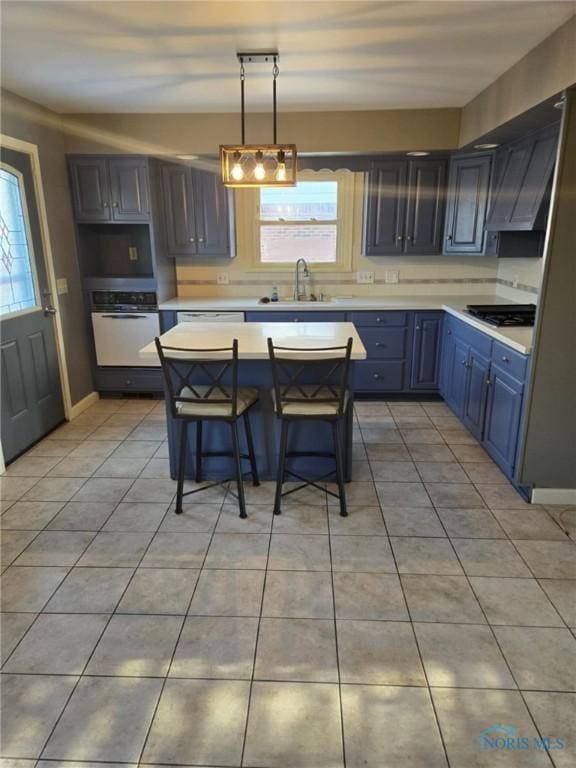 kitchen with sink, a breakfast bar, white oven, a wealth of natural light, and decorative light fixtures