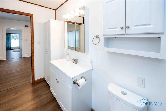 bathroom with toilet, hardwood / wood-style flooring, and vanity