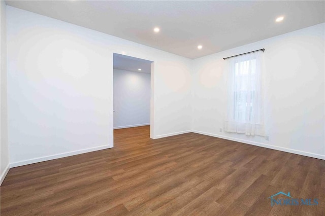 spare room with dark wood-type flooring