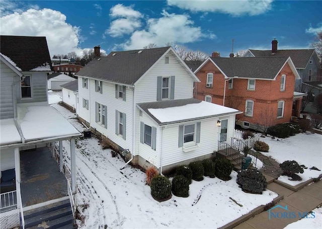 snow covered house featuring central air condition unit