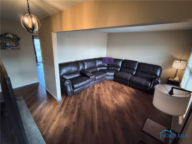 living room with plenty of natural light, dark hardwood / wood-style floors, and a notable chandelier