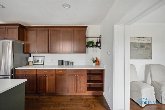 kitchen featuring stainless steel fridge and dark hardwood / wood-style flooring